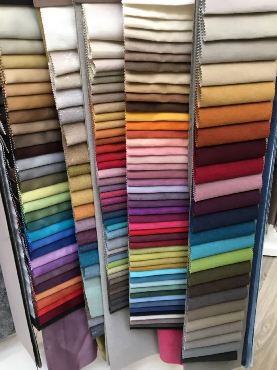 Swatches of curtain fabric materials including cotton, linen, velvet, and jacquard on a window ledge in a UAE apartment